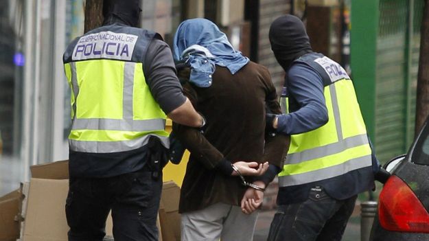 Hiszpańscy policjanci prowadzą zatrzymanego podczas akcji dżihadystę