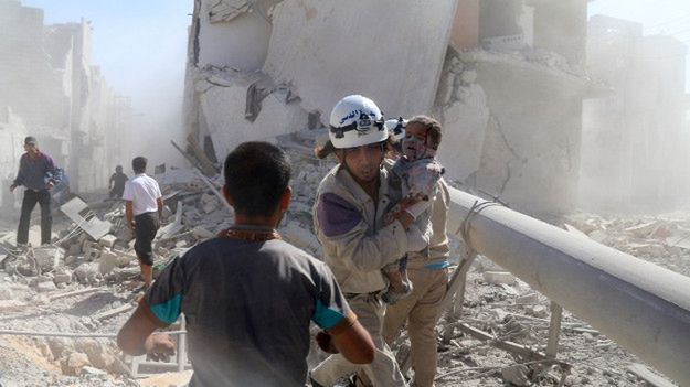 Ratownik pomaga rannemu dziecku po rzekomym ataku z użyciem bomby beczkowej, Aleppo, wrzesień 2014 r.