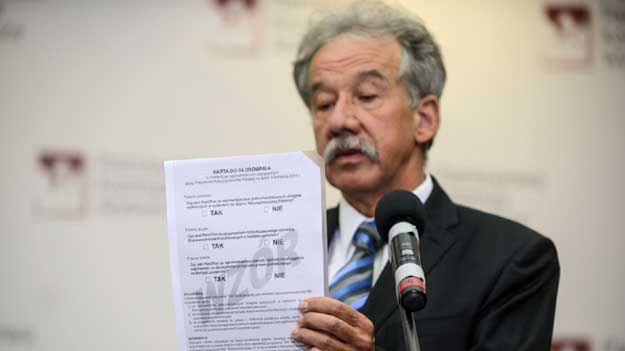 Wojciech Hermeliński prezentuje kartę do głosowania w referendum