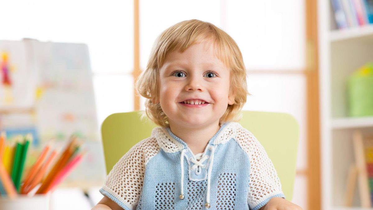 Dziecko bawi się przy stoliku. 