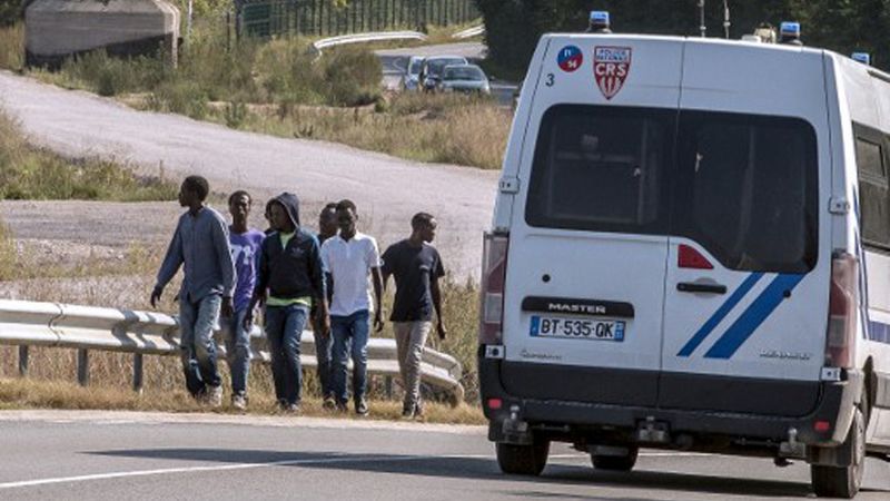 Imigranci na autostradzie w pobliżu Calais.