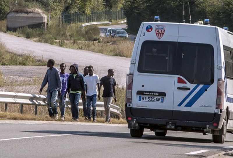 Imigranci na autostradzie w pobliżu Calais.