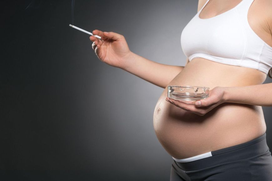 Kobieta w ciąży paląca papierosy