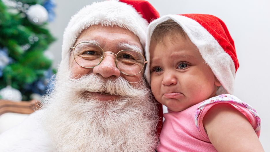 Płaczące dzieci na kolanach Mikołaja