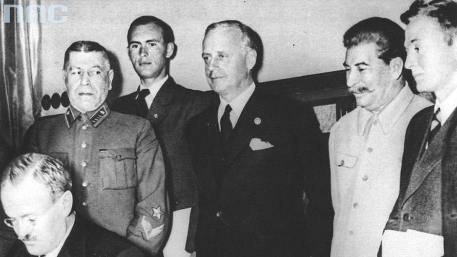 Minister spraw zagranicznych Związku Radzieckiego Wiaczesław Mołotow składa podpis pod paktem. Za nim stoją m.in. minister spraw zagranicznych III Rzeszy Joachim von Ribbentrop (trzeci od lewej) oraz przywódca Związku Radzieckiego Józef Stalin (czwarty od lewej).
