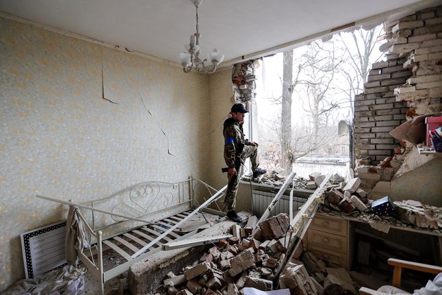 Igor, ukraiński żołnierz z WOT przeprowadza inspekcję zniszczonego przez Rosjan budynku. Irpień, obwód kijowski.