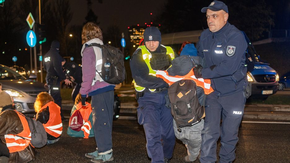 WARSAW, POLAND - 2024/11/27: Police officers remove a protester from the road during the demonstration. The Last Generation (Ostatnie Pokolenie) initiated blockades on Wislostrada to protest Donald Tusk's climate policies, with plans for weekly demonstrations to symbolize sustained resistance. Known for nonviolent disobedience, the group demands reallocating road construction funds to regional public transport and introducing a unified 50 PLN monthly ticket. They accuse Prime Minister Tusk of ignoring their calls and urge him to commit publicly to climate action. Claiming to be Poland's loudest climate campaign, Last Generation presses for immediate systemic changes to address the climate crisis. (Photo by Marek Antoni Iwanczuk/SOPA Images/LightRocket via Getty Images)
