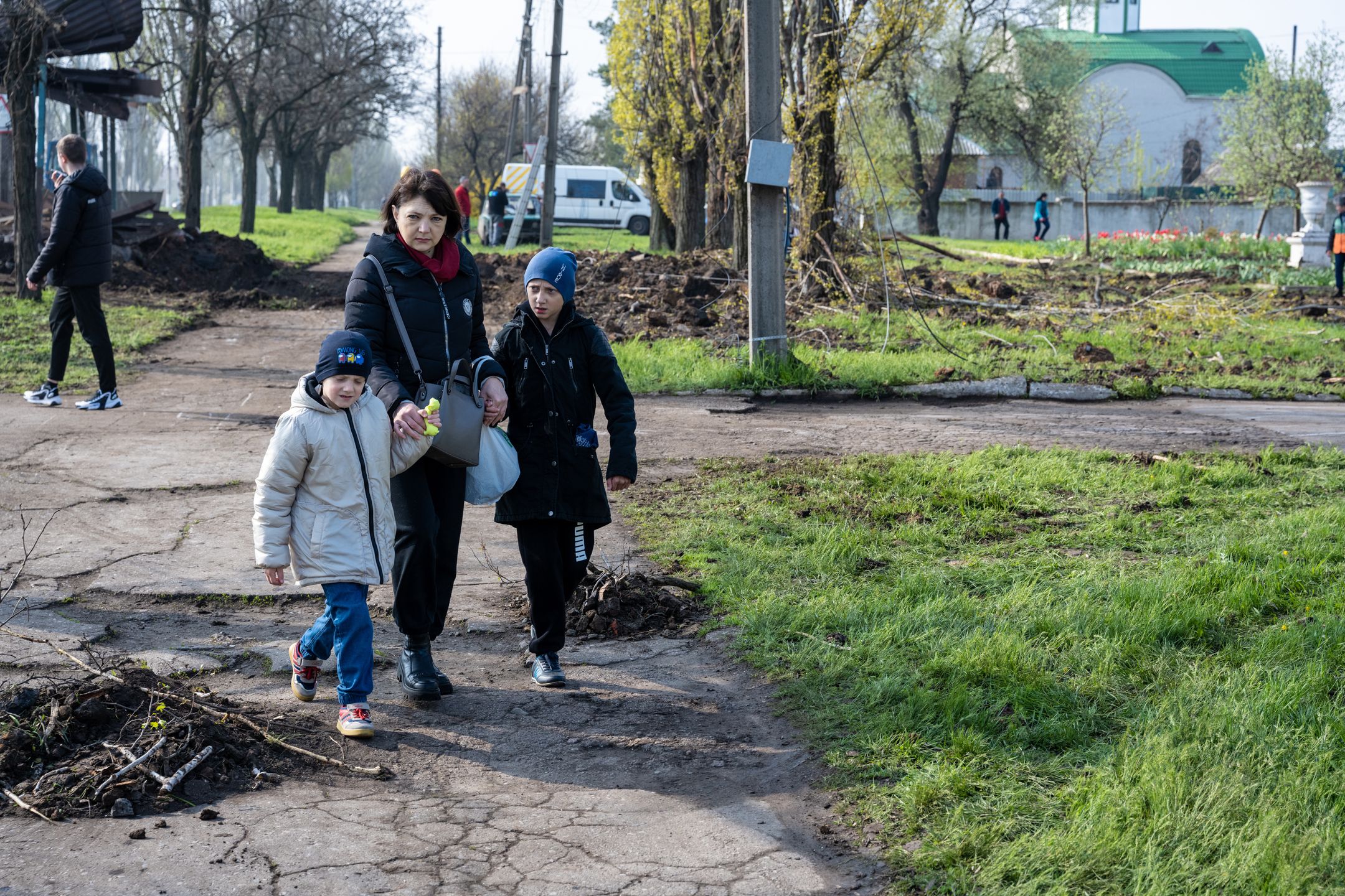 KRAMATORSK, UKRAINE - APRIL 24: A Ukrainian woman walks with two children near an impact crater after two Russian rockets struck overnight beside a school in Kramatorsk, Ukraine, on April 24, 2023. While fighting has continued to rage across the Donbas region, and a Ukrainian spring counteroffensive is expected at any time, Russian forces have fired rockets at residential areas in cities miles back from the frontline, and across Ukraine. (Photo by Scott Peterson/Getty Images)