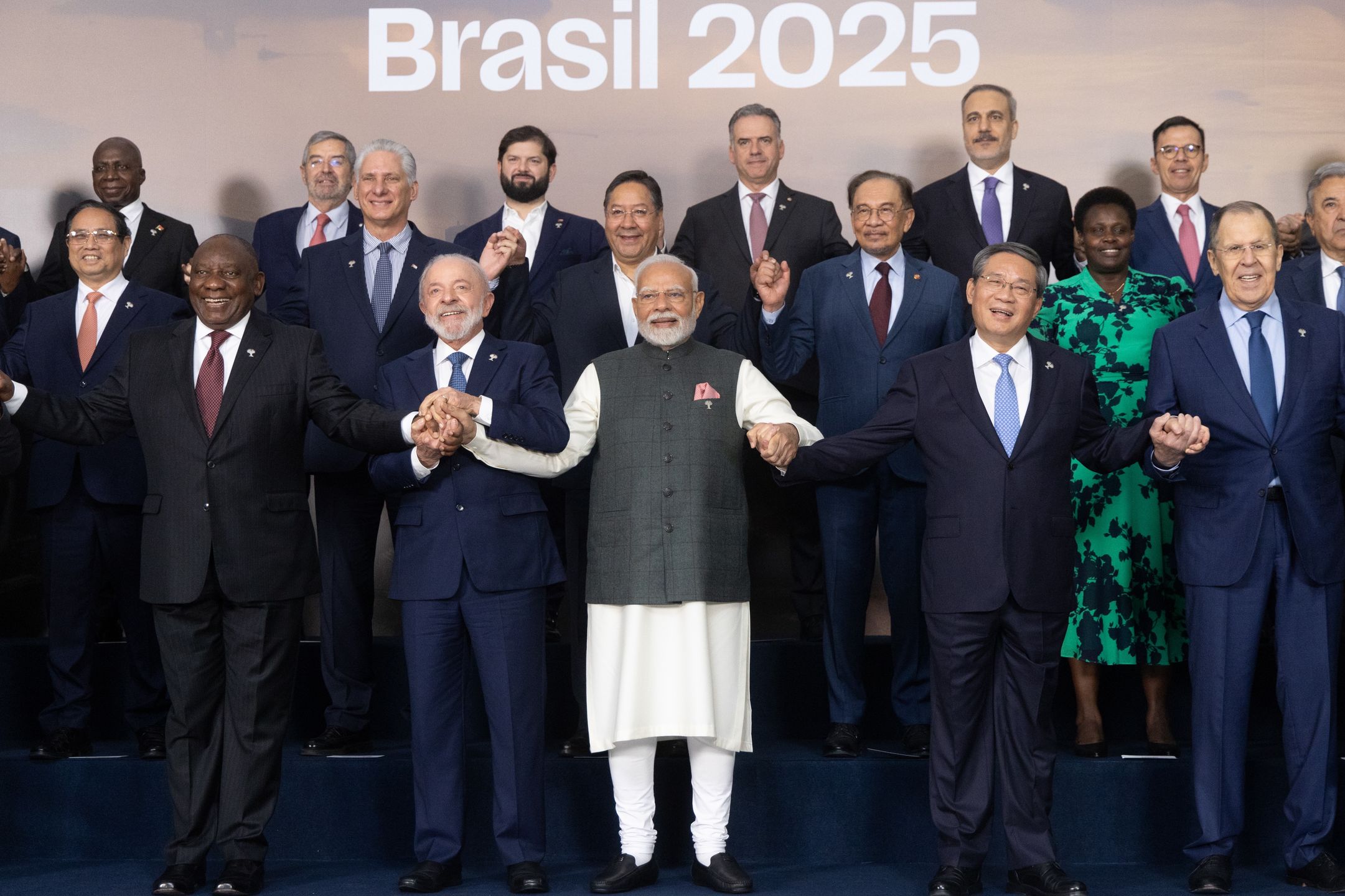 Cyril Ramaphosa, South Africa's president, from front left, Luiz Inacio Lula da Silva, Brazil's president, Narendra Modi, India's prime minister, Li Qiang, China's premier, and Sergei Lavrov, Russia's foreign minister, join hands during the family photo at the BRICS Summit in Rio de Janeiro, Brazil, on Monday, July 7, 2025. BRICS leaders condemned US and Israeli attacks on Iran and called on Prime Minister Benjamin Netanyahu's government to withdraw troops from the Gaza Strip, urging "just and lasting" solutions to conflicts across the Middle East. Photographer: Dado Galdieri/Bloomberg via Getty Images