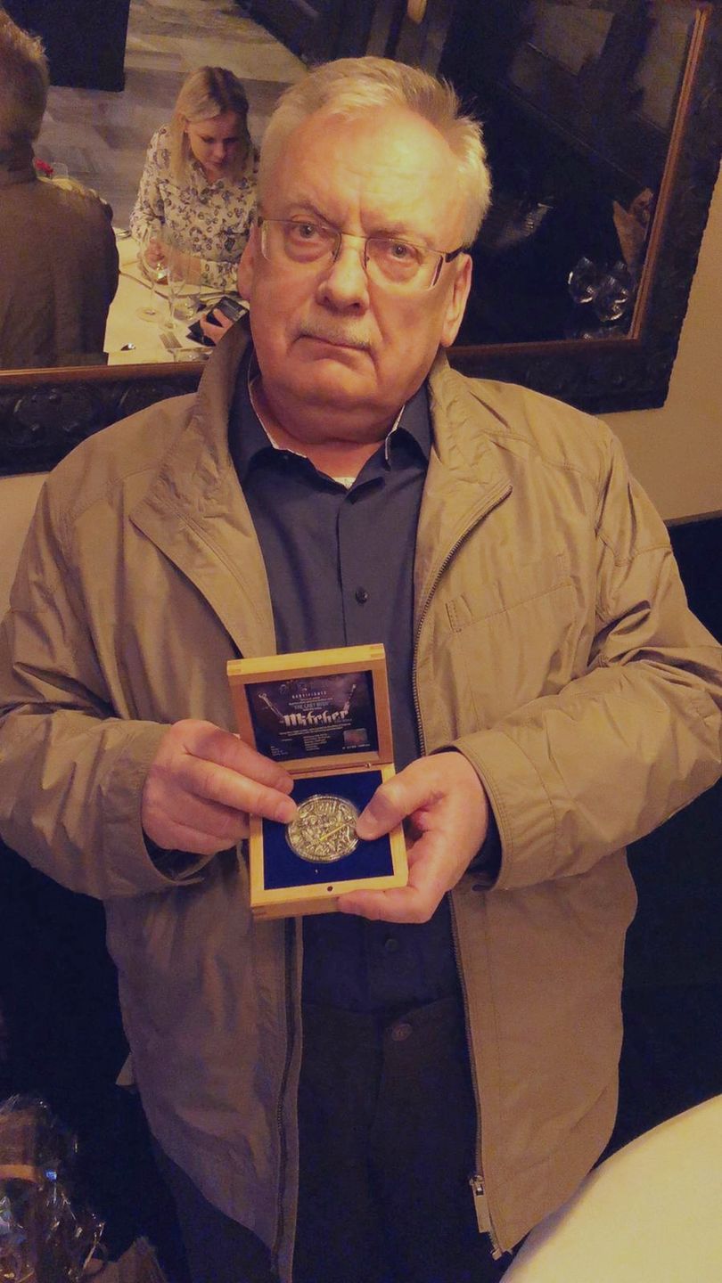 Andrzej Sapkowski z monetą Ostatnie Życzenie
