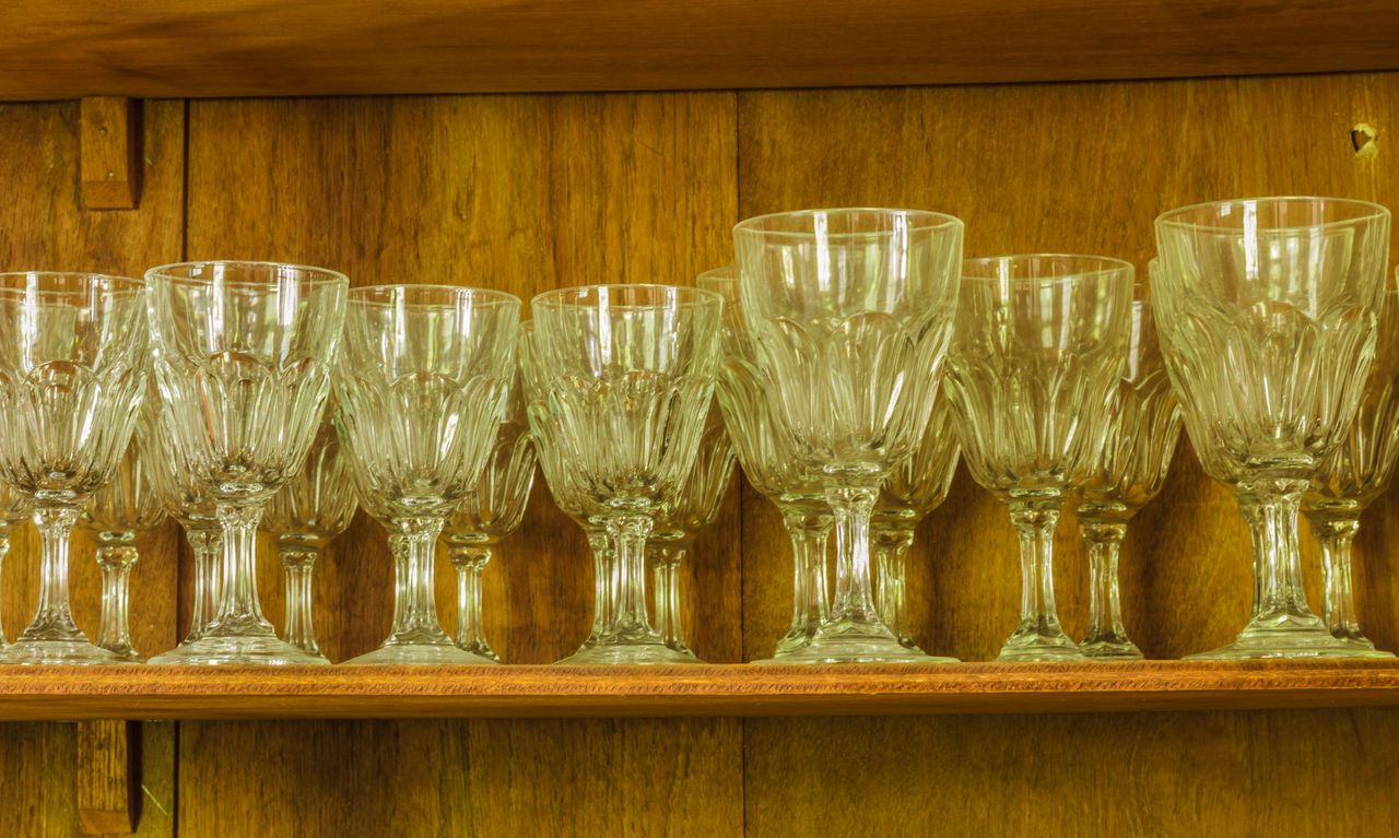 Crystal wine glasses arranged in a wooden cabinet in the kitchen.