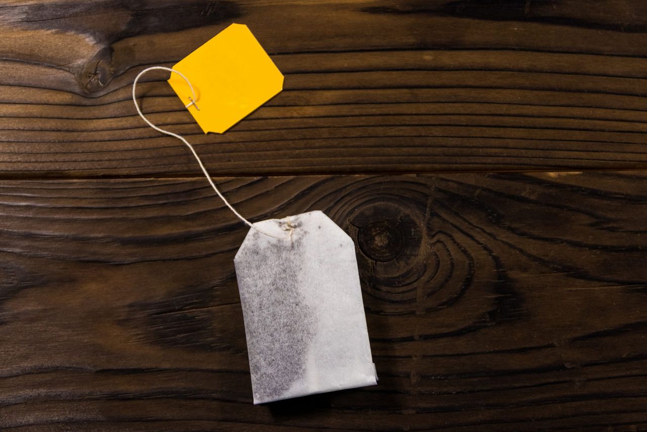 Tea bag on wooden table. Top view