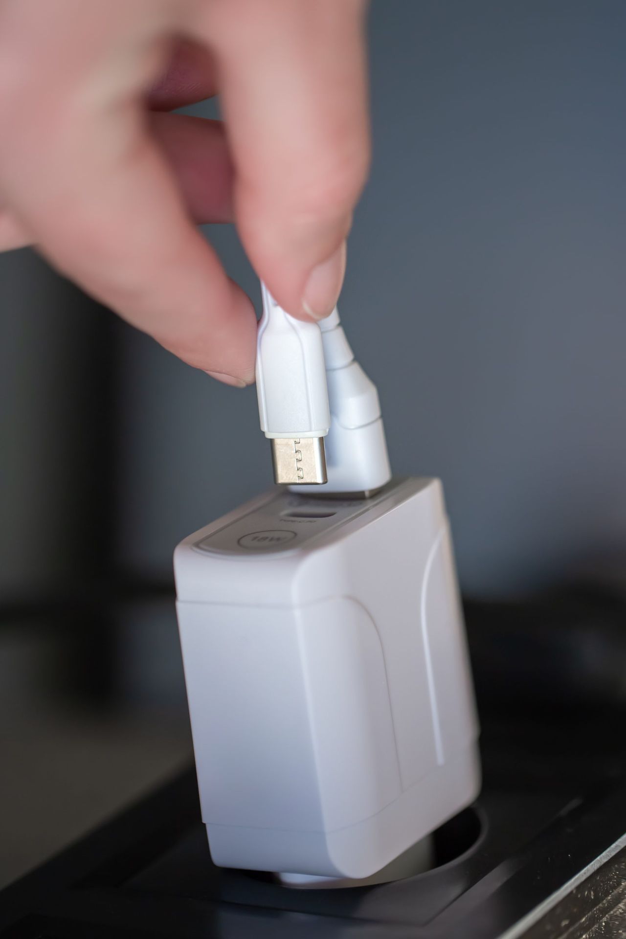 USB charging for gadgets on a blurred background of the room, close-up. The concept of technology in everyday life.