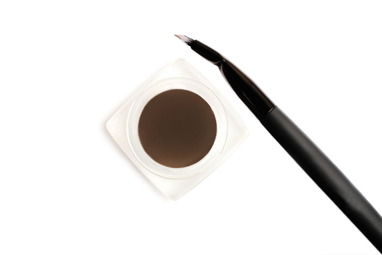Dark brown dipbrow pomade with special brush.Eyebrow cosmetics.Make up concept.Isolated on white.