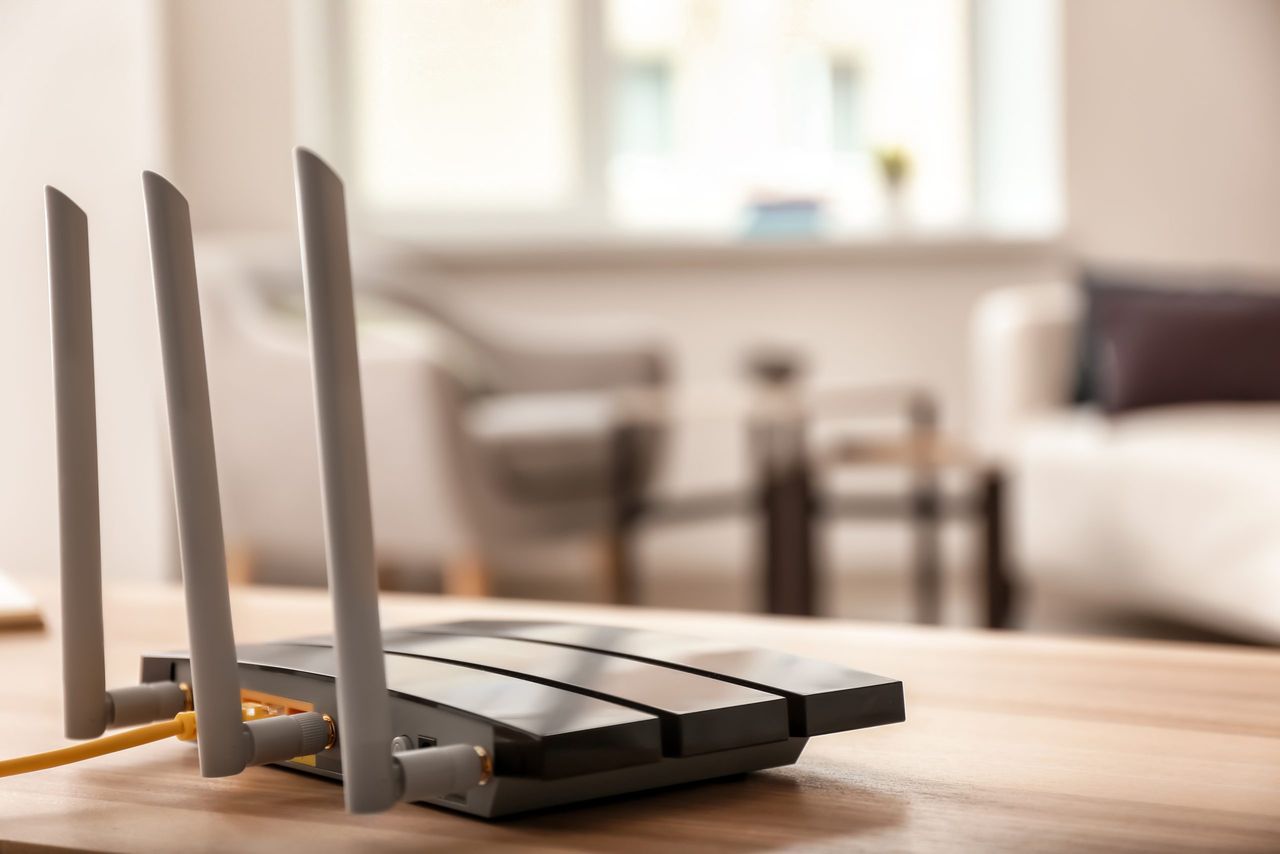 Modern wi-fi router on wooden table in room