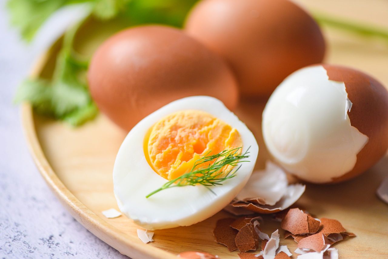 Eggs breakfast, fresh peeled eggs menu food boiled eggs in a wooden plate decorated with leaves green dill and eggshell, cut in half egg yolks for cooking healthy eating