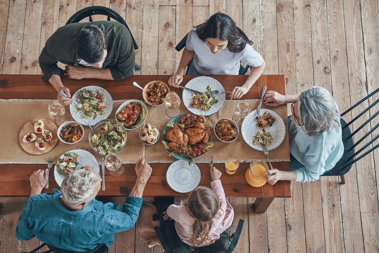 Top view of multi-generation family communicating and smiling while having dinner together