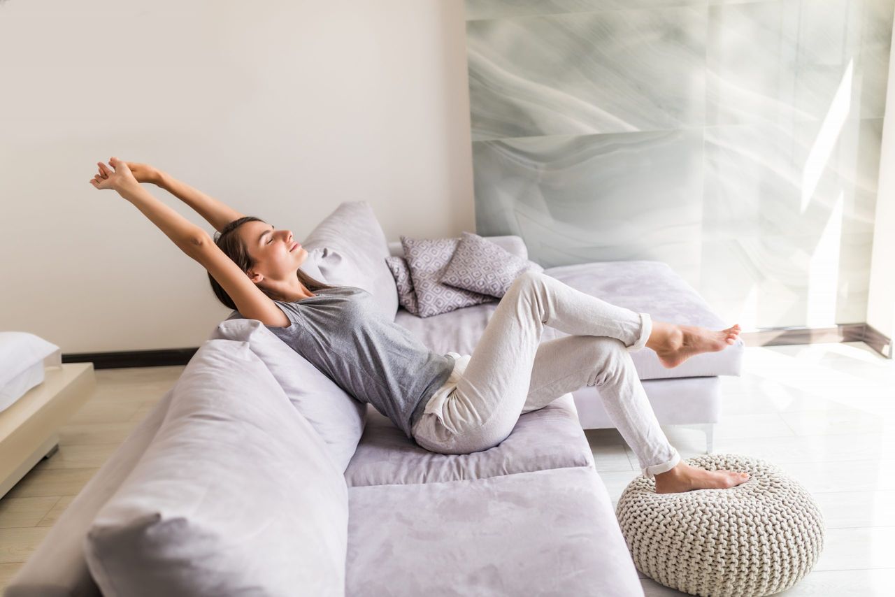 Closeup of a smiling young woman lying on couch