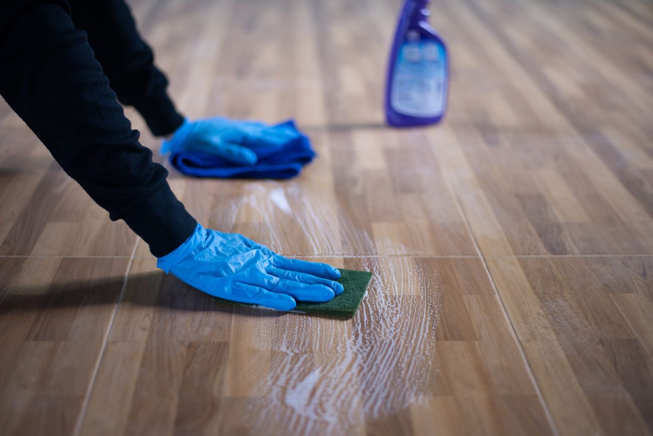 People cleaning floor tiles, Close up to hand is cleaning a stain on a floor tile with disinfectant.