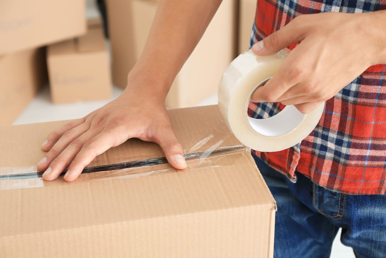 Young man packing box, indoors