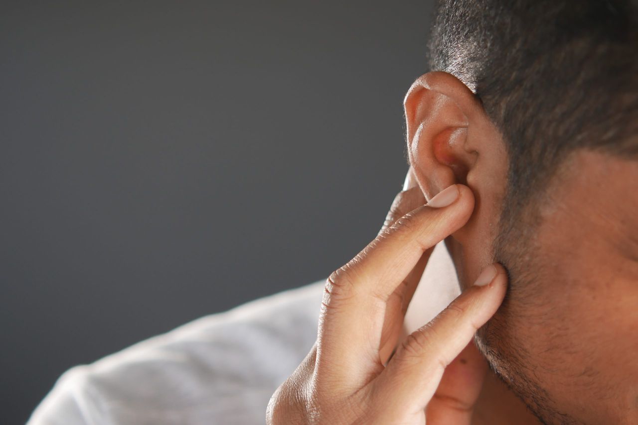 young man having ear pain touching his painful ear