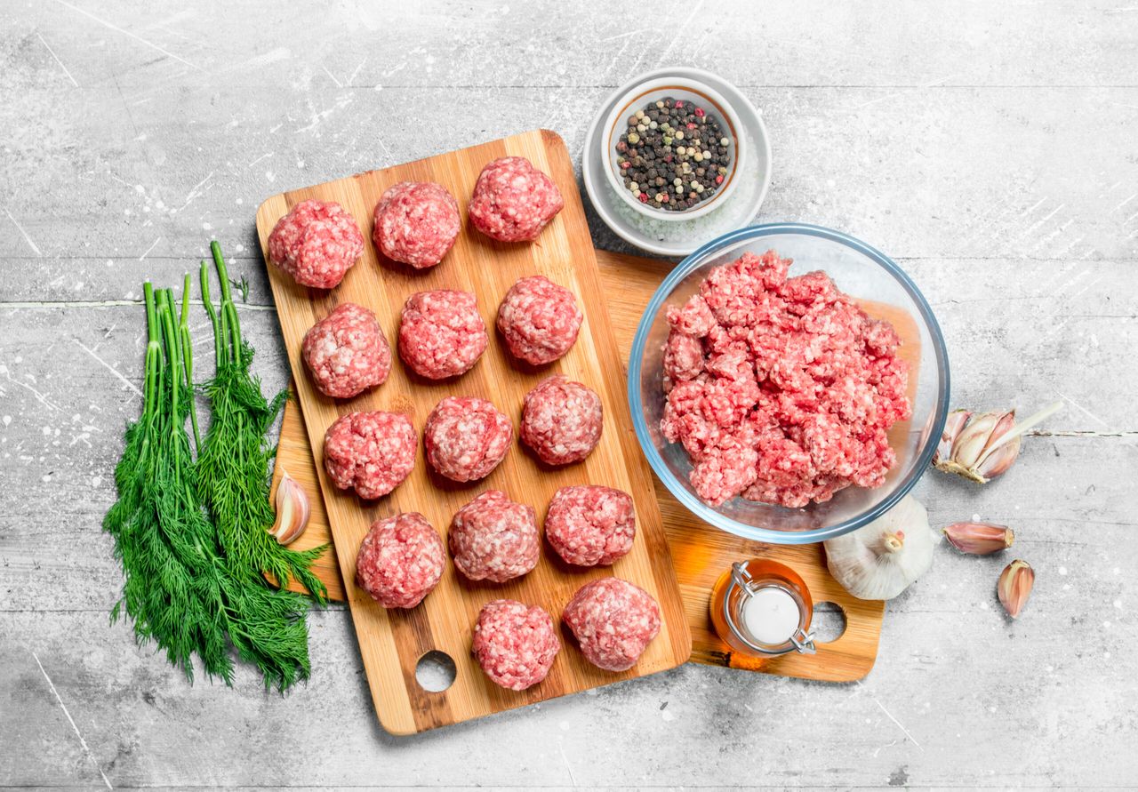 Raw beef meatballs with spices and fragrant dill . On a rustic background.