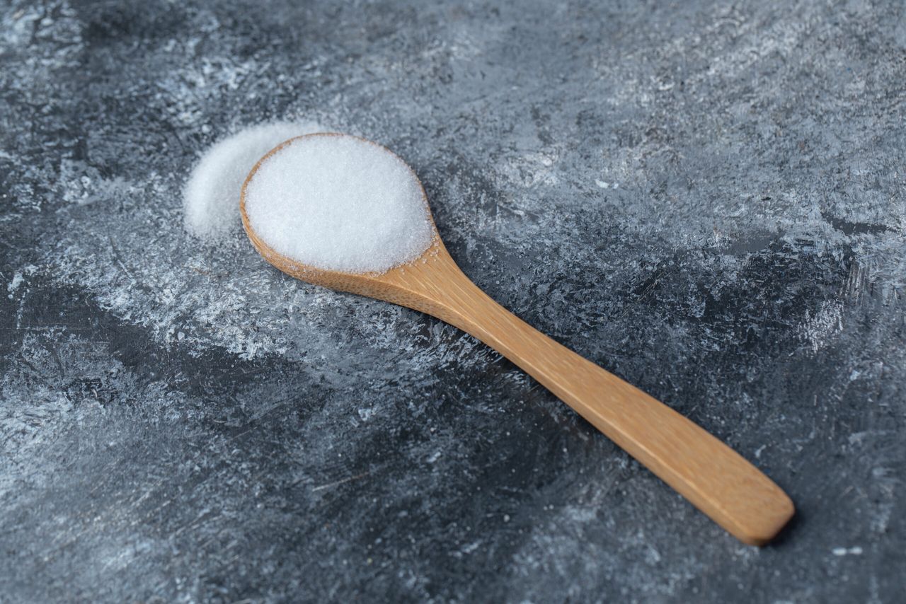 Salt in a wooden spoon on a marble background. High quality photo