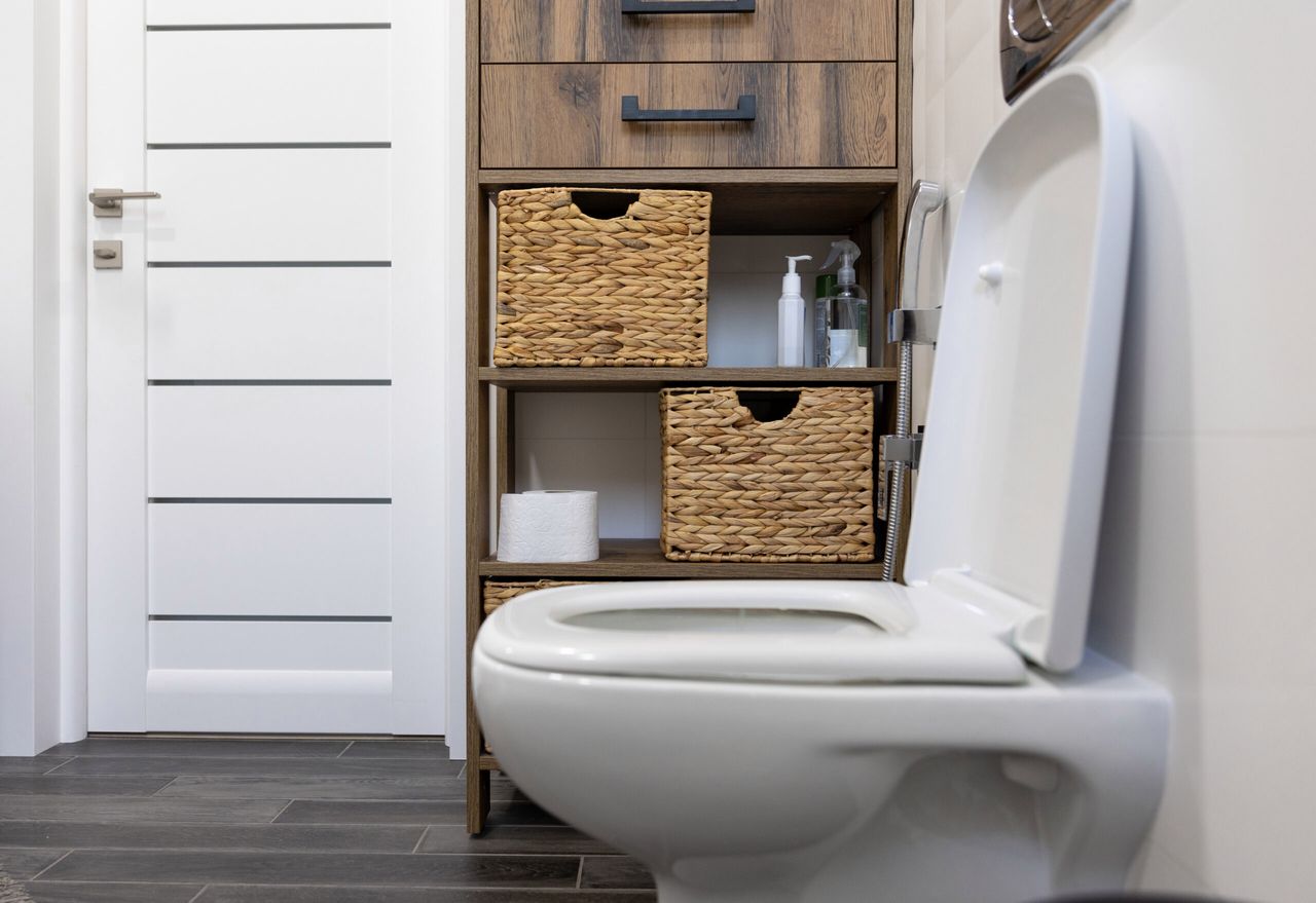 White bathroom with a toilet and straw details.