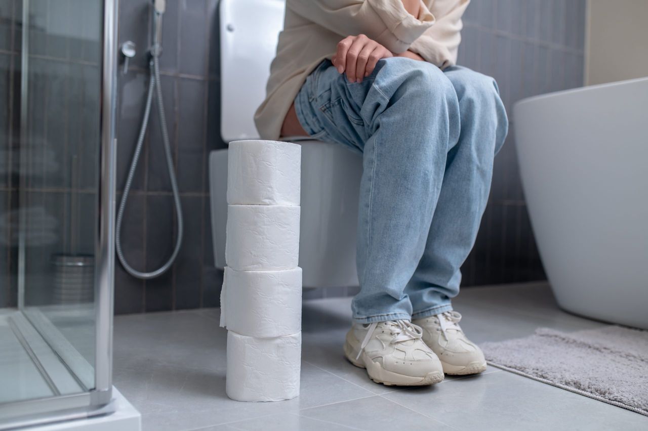 In the toilet. A young woman sitting on a toilet bowl
