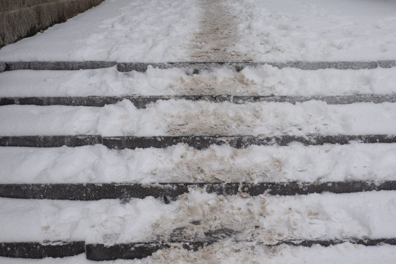 concrete stairs covered with snow, cold winter day. poor street cleaning