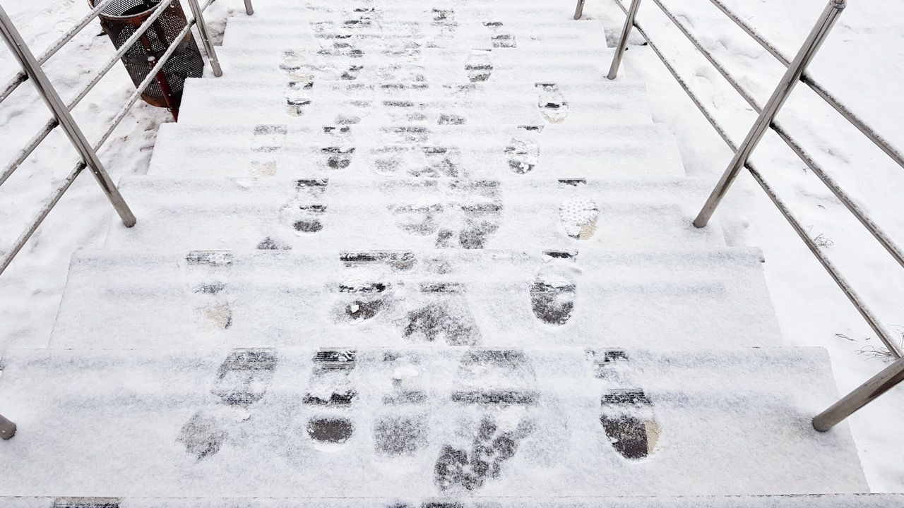 stair railings and snow. Slippery steps, ice covered with footprints, horizontal shot outside