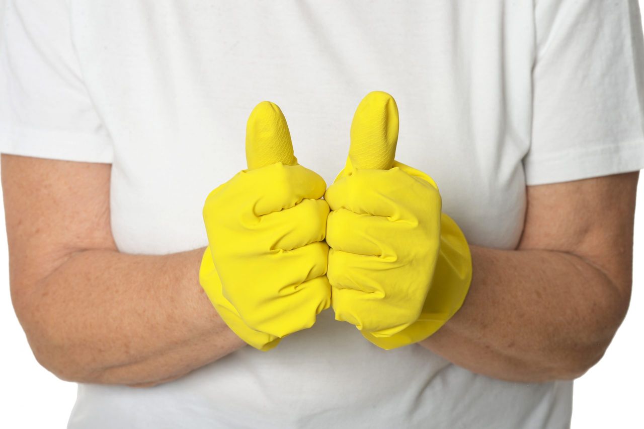 Hands in yellow gloves  showing thumbs up, isolated on white background