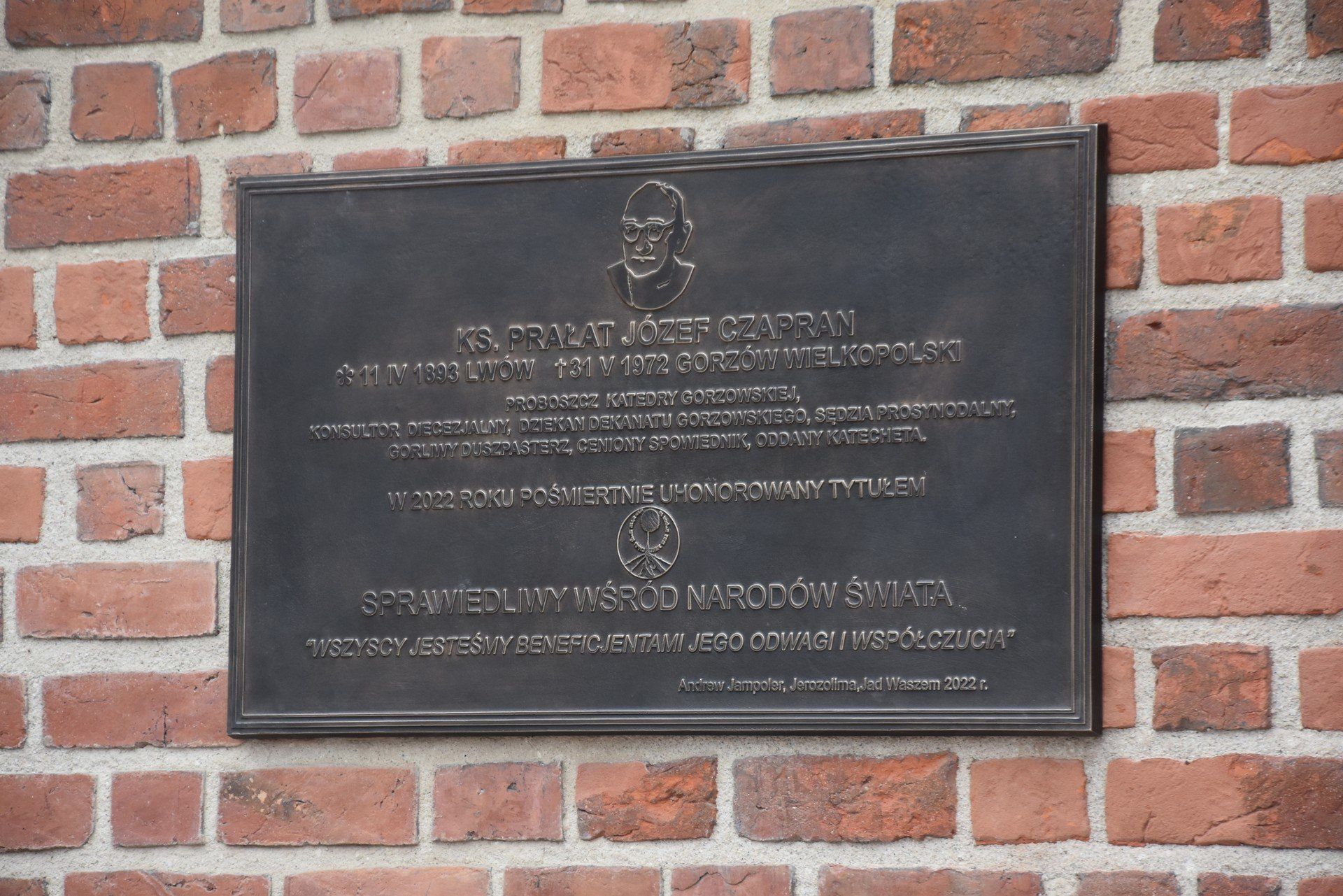 Tablica pamiątkowa zawisła na zewnętrznej części muru katedralnego prezbiterium.