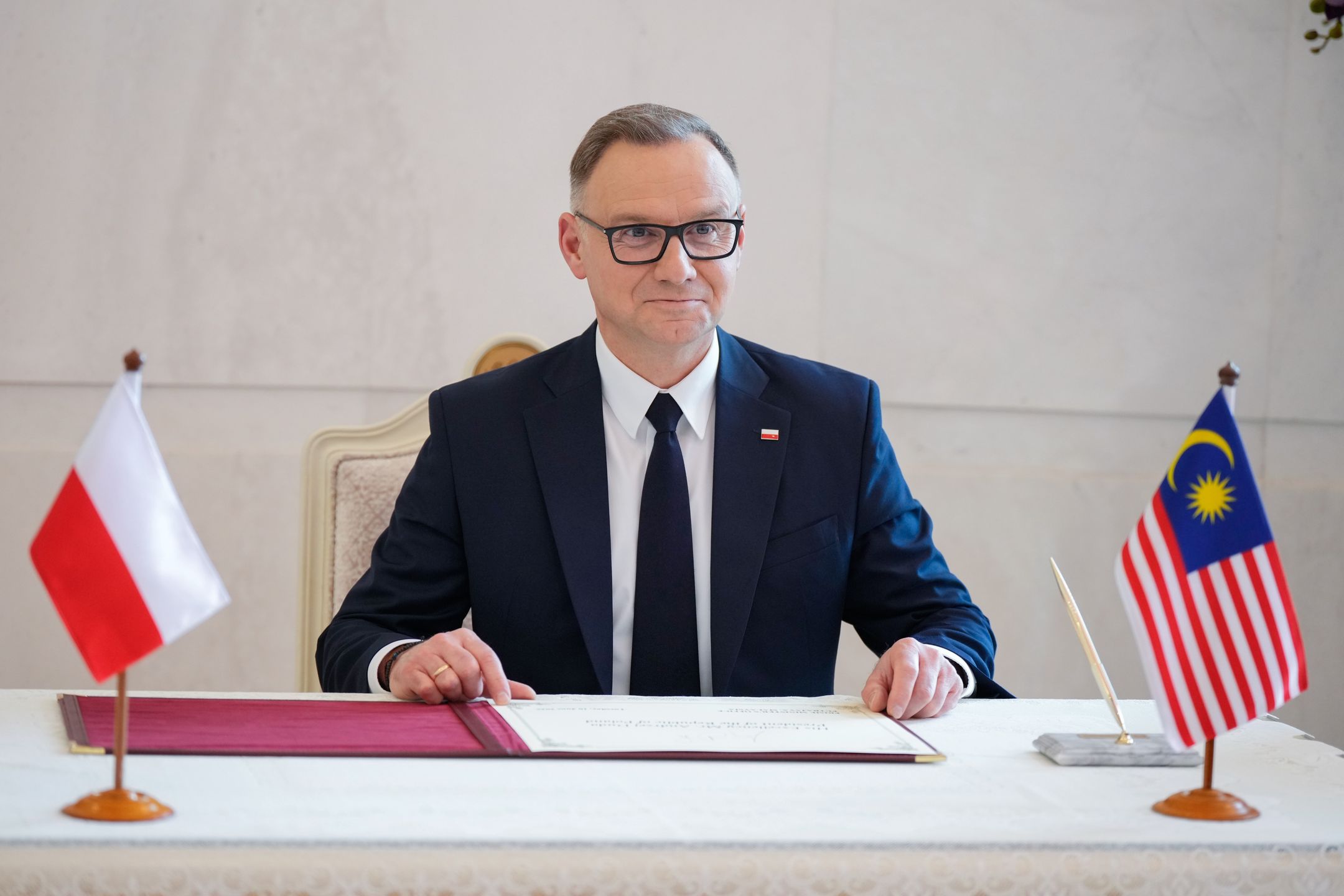 Poland's outgoing President Andrzej Duda signs a guest book before a meeting with Malaysian Prime Minister Anwar Ibrahim in Putrajaya, Malaysia, 10 June 2025. EPA/Vincent Thian / POOL Dostawca: PAP/EPA.