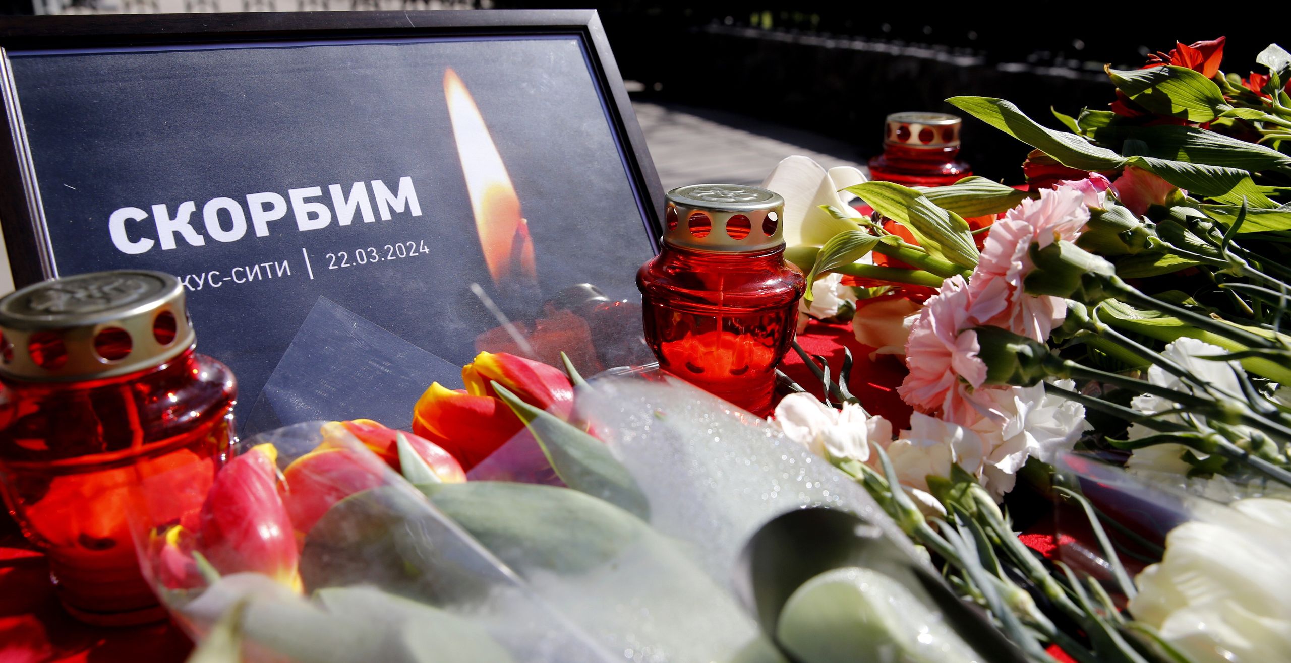 epaselect epa11238291 A sign that reads 'We mourn 22.03.2024' is seen next to flowers laid by people in front of the Russian Embassy as a sign of condolences to the people of Russia after the terrorist attack at Crocus City Hall, in Bishkek, Kyrgyzstan, 23 March 2024. On 22 March evening, a group of up to five gunmen attacked the Crocus City Hall in the Moscow region, Russian emergency services said. 93 people were killed and more than 100 others were hospitalized, the Investigative Committee confirmed. EPA/IGOR KOVALENKO Dostawca: PAP/EPA.