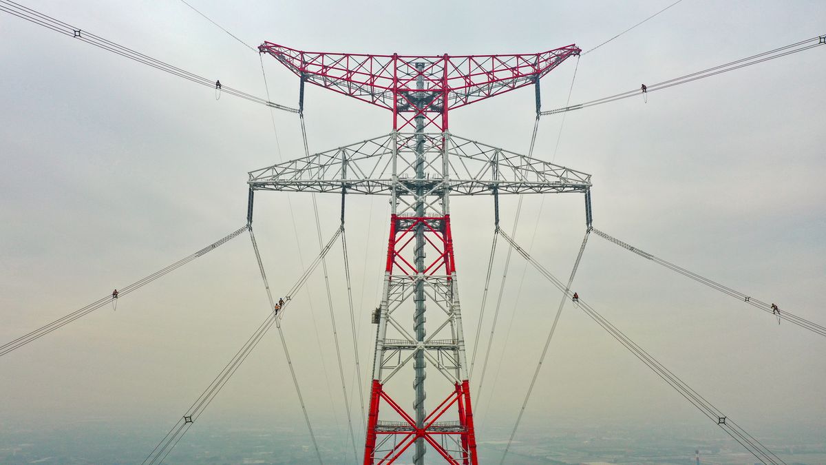 NANJING, CHINA - FEBRUARY 20, 2023 - Construction workers inspect the construction site of the world's 385-meter high power transmission tower, a 500-kv transmission line from Fengcheng to Meili in Nanjing, Jiangsu Province, China, Feb. 20, 2023. It is understood that when the project is completed and put into operation, new energy from the north bank of the Yangtze River will be continuously sent to the South of the Yangtze River, which will comprehensively improve the green and sustainable development capacity of the Yangtze River Delta and meet the daily demand of about 8 million households. (Photo credit should read CFOTO/Future Publishing via Getty Images)