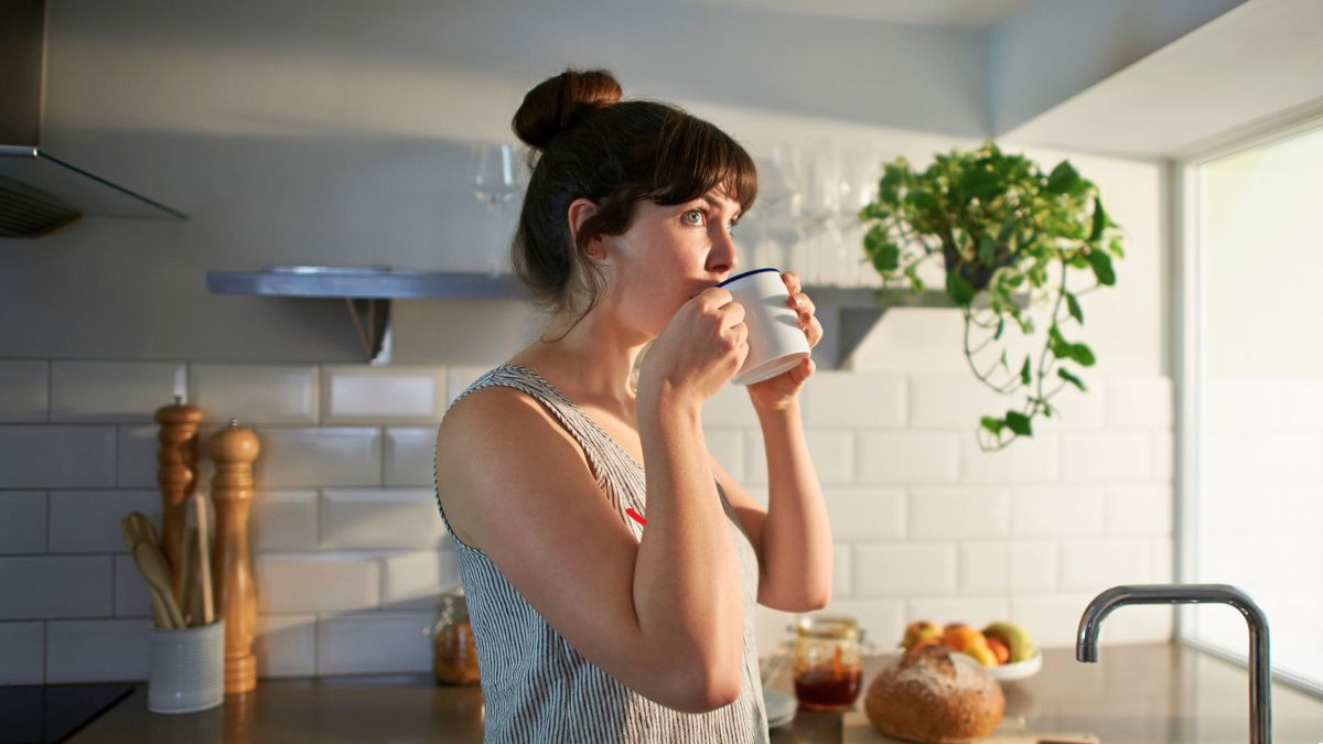 Kobieta pije kawę w kuchni