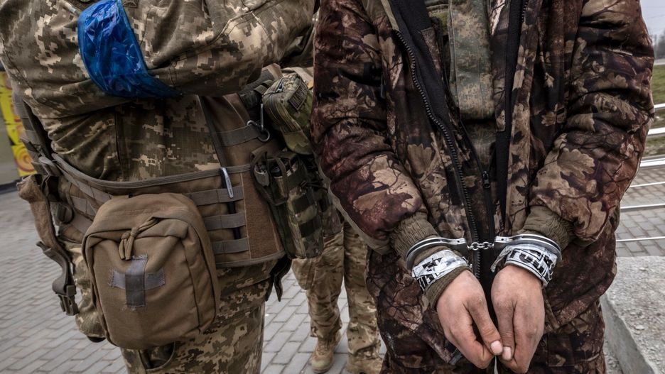 arch50TOPSHOT - A Ukrainian serviceman stands past a handcuffed Russian soldier in Kharkiv on March 31, 2022. - Russian forces are repositioning in Ukraine to strengthen their offensive on the Donbass, Nato said on March 31, 2022, on the 36th day of the Russian-Ukrainian conflict, as shelling continues in Kharkiv (north) and Mariupol (south). (Photo by FADEL SENNA / AFP)FADEL SENNA