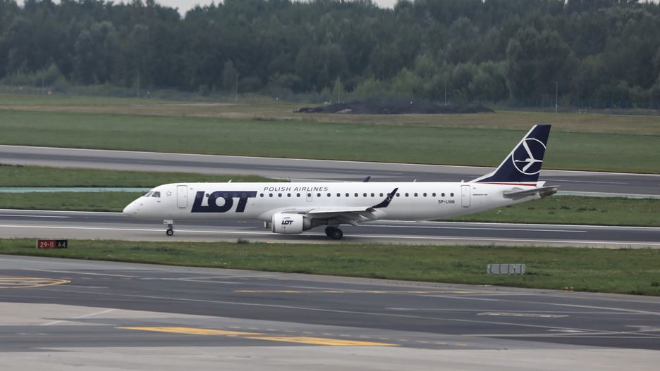 Warszawa, 22.08.2021. Samolot PLL LOT typu Embraer 195 z osobami ewakuowanymi z Afganistanu na lotnisku Okęcie w Warszawie, 22 bm. Szef KPRM Michał Dworczyk podał w sobotę, że lista osób, które wspierały polskich dyplomatów i polskich żołnierzy w Afganistanie i chciałyby skorzystać z możliwości ewakuacji jest długa i rośnie, ponieważ cały czas zgłaszają się kolejne osoby. (jm) PAP/Rafał Guz