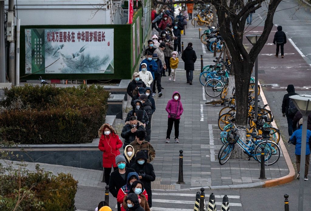 China Battles Outbreaks As Country Records Record CasesBEIJING, CHINA - NOVEMBER 30: Residents wear masks to prevent the spread of COVID-19 as they wait in a long line for nucleic acid tests at a public testing site near an area where communities are in lockdown on November 30, 2022 in Beijing, China. In recent days, China has been recording its highest number of COVID-19 cases since the pandemic began, as authorities are sticking to their strict zero tolerance approach to containing the virus with lockdowns, mandatory testing, mask mandates, and quarantines as it struggles to contain outbreaks.In an effort to try to bring rising cases under control, the government last week closed most stores and restaurants for inside dining, switched  schools to online studies, and told people to work from home among other measures. (Photo by Kevin Frayer/Getty Images)Kevin Frayer