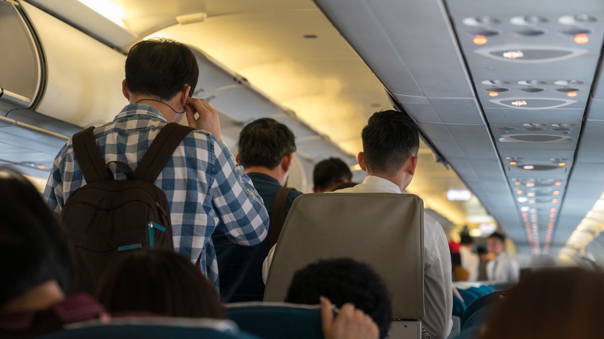 Ludzie stoją w przejściu samolotu przed opuszczeniem pokładu