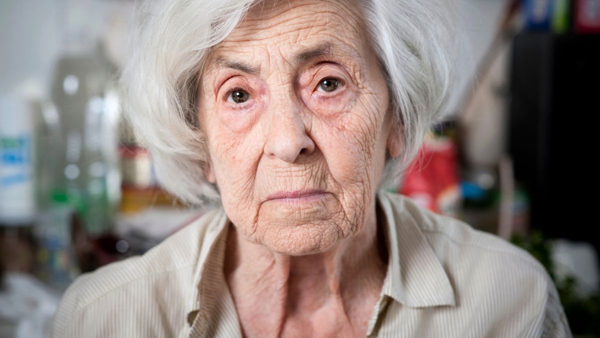 Starsza kobieta patrzy smutnym wzrokiem