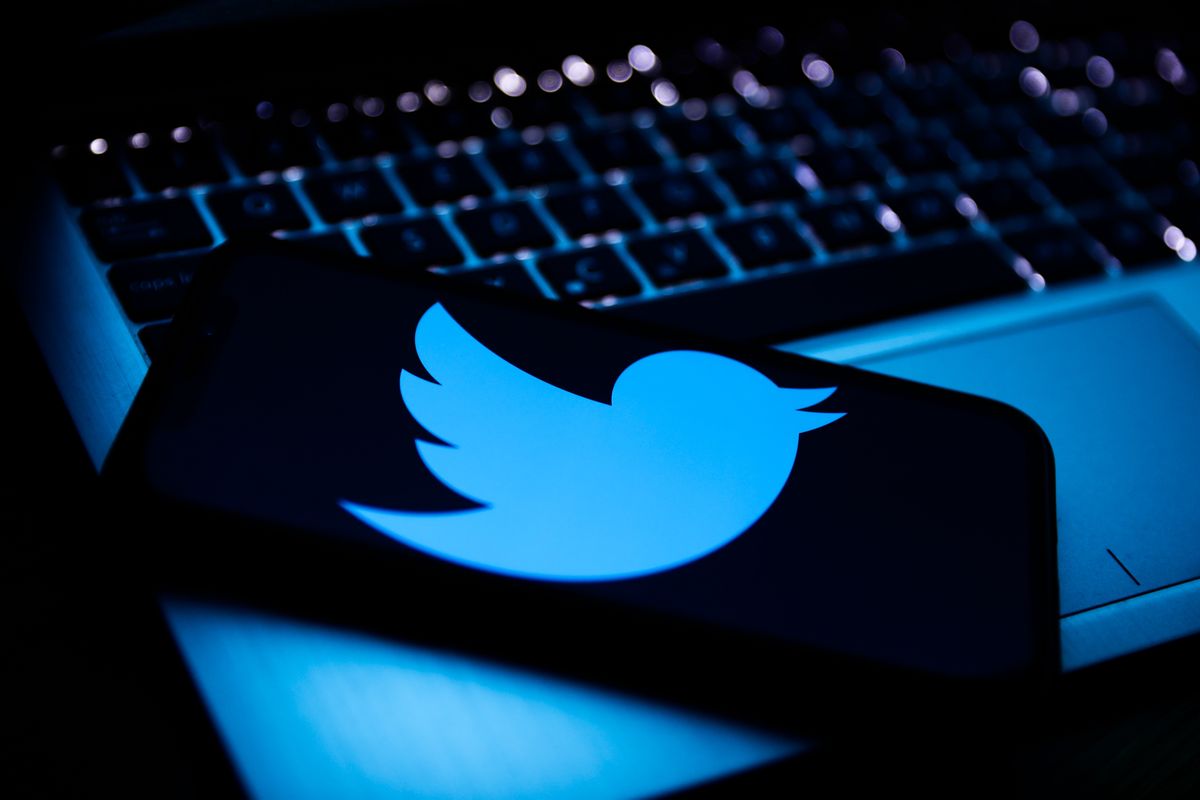 Twitter logo displayed on a phone screen and a laptop keyboard are seen in this illustration photo taken in Krakow, Poland on April 9, 2022. (Photo by Jakub Porzycki/NurPhoto via Getty Images)