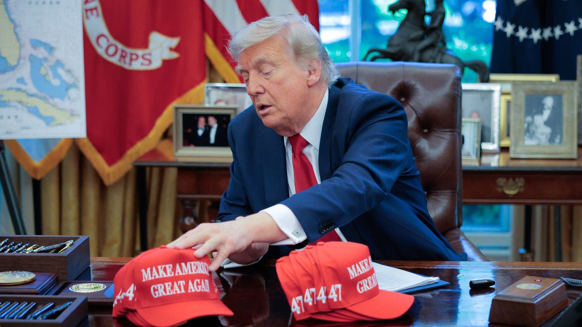 WASHINGTON, DC - APRIL 23: U.S. President Donald Trump adjusts "Make America Great Again" hats as he prepares to sign executive orders in the Oval Office at the White House on April 23, 2025 in Washington, DC. The seven executive orders were related to education policy. (Photo by Chip Somodevilla/Getty Images)