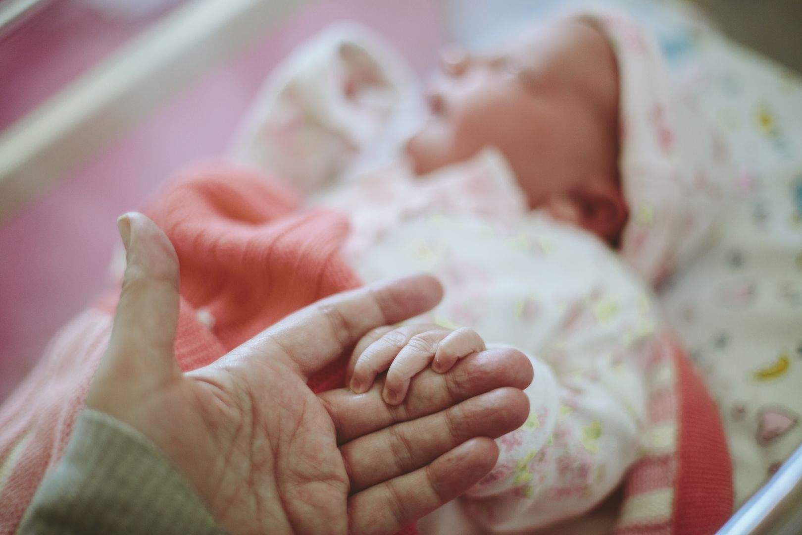 Noworodek trzyma mamę za rękę (zdjęcie ilustracyjne)