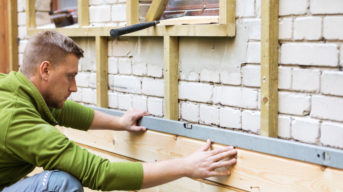 Na zdjęciu pracownik pracujący przy wykończeniu domu