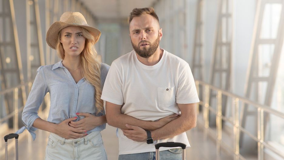 Couple suffering from stomachache, arriving at airport