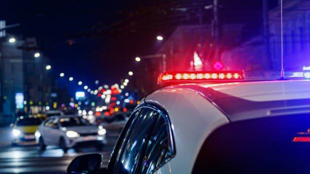 police car lights at night in city with selective focus and blurry car traffic in the bokeh