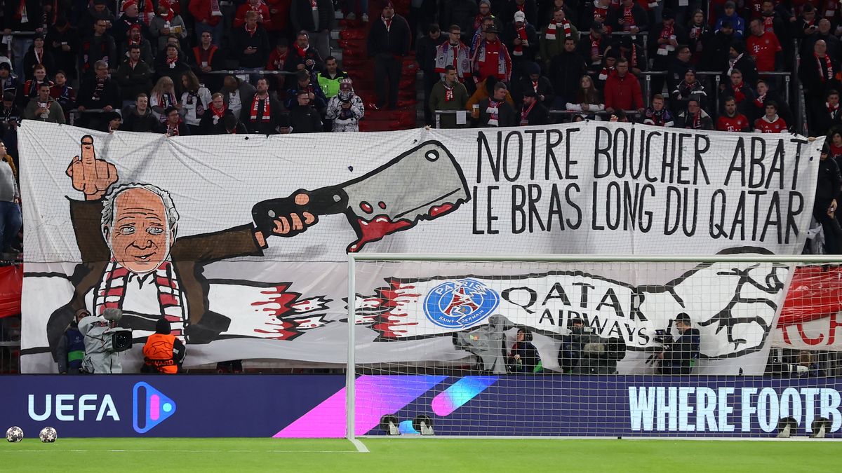 MUNICH, GERMANY - MARCH 08: (EDITORS NOTE: Image contains profanity) FC Bayern Munich fans hold up a banner reading "Our butcher slaughters the long arm of Qatar" prior to the UEFA Champions League round of 16 leg two match between FC Bayern München and Paris Saint-Germain at Allianz Arena on March 08, 2023 in Munich, Germany. (Photo by Alex Grimm/Getty Images)