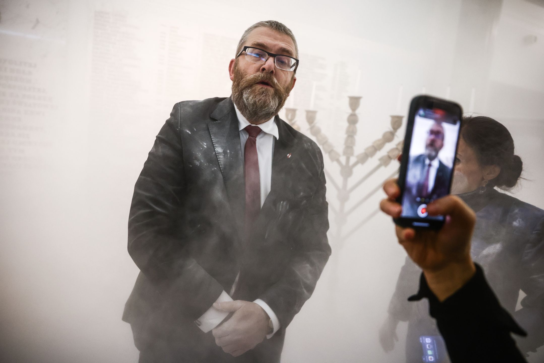 Grzegorz Braun, a member of the far-right Confederation party is seen after using a fire extinguisher on to put out candles on a menorah that was lit during Hannukah celebration in the parliament building in Warsaw, Poland on December 12, 2023.  (Photo by Beata Zawrzel/NurPhoto via Getty Images)